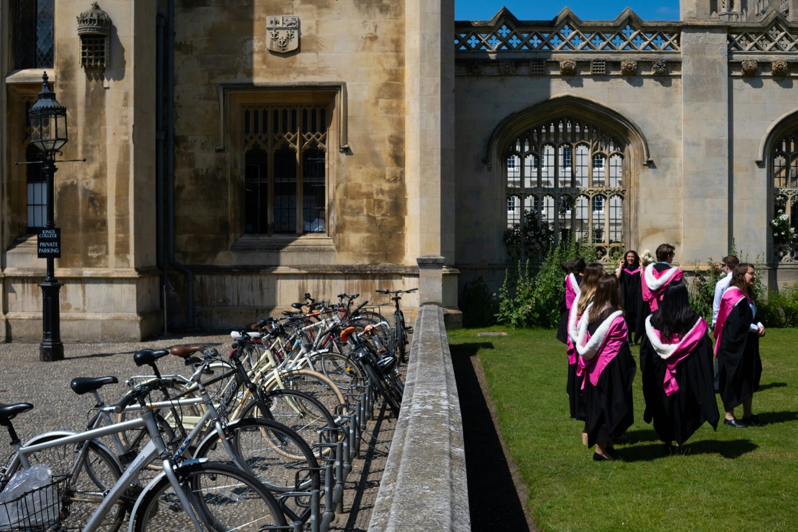 a group of women walking down a sidewalk next to bicycles