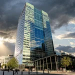One Churchill Place, Barclays' global headquarters at Canary Wharf, London. Photo: Acabashi / Wikimedia Commons (CC BY-SA 4.0), AI-rendered editorial composite.