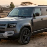 Land Rover Defender 110 parked on open ground at sunset. AI image grounded in a real photo by Alexander Migl, Wikimedia Commons, CC BY-SA 4.0.