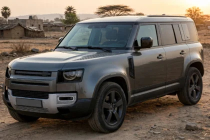 Land Rover Defender 110 parked on open ground at sunset. AI image grounded in a real photo by Alexander Migl, Wikimedia Commons, CC BY-SA 4.0.