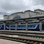 Dnipro railway station, Ukraine, with a blue passenger train at the platform.