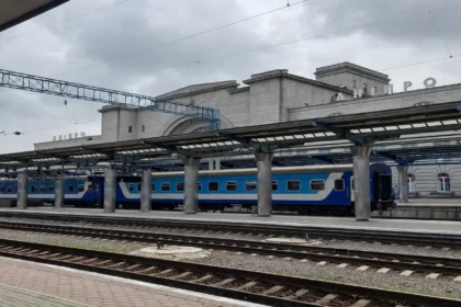Dnipro railway station, Ukraine, with a blue passenger train at the platform.