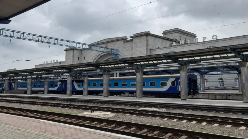 Dnipro railway station, Ukraine, with a blue passenger train at the platform.