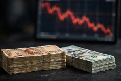 Stacks of Indian rupee and US dollar notes with a falling forex chart, representing India's declining foreign exchange reserves.