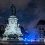Monument a la Republique at Place de la Republique, Paris, under the overnight curfew during the October 2026 riots. Base photo: Dr. Thomas Liptak / Wikimedia Commons (CC BY-SA 4.0), news-style composite.