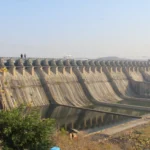 Sardar Sarovar Dam scene, based on a photo by Vijayakumarblathur / Wikimedia Commons (CC BY-SA 4.0).