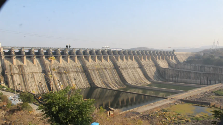 Sardar Sarovar Dam scene, based on a photo by Vijayakumarblathur / Wikimedia Commons (CC BY-SA 4.0).