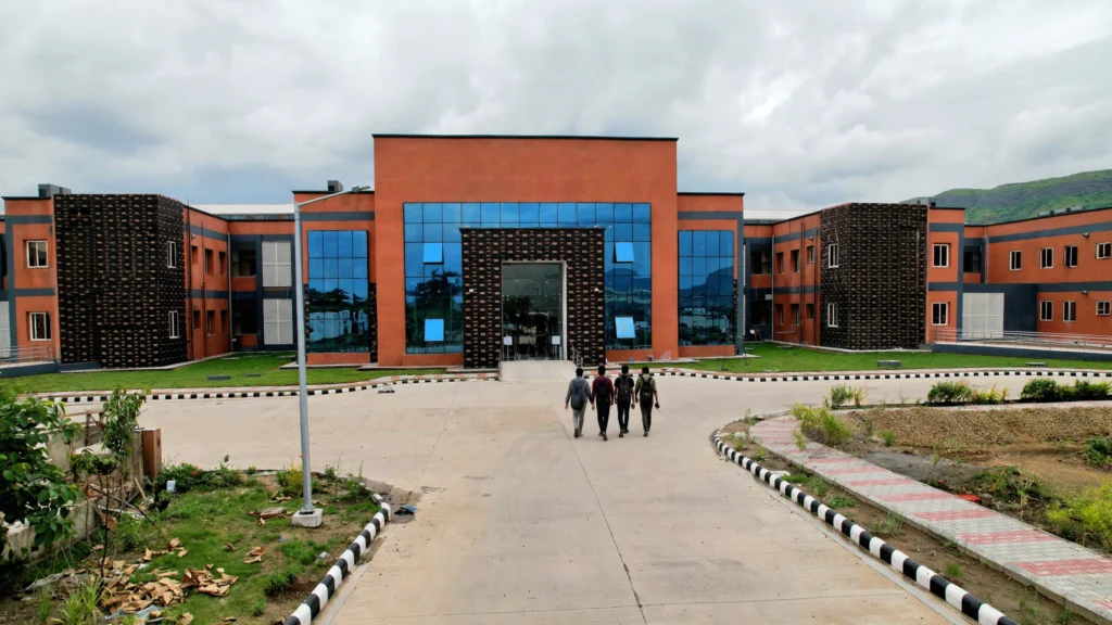 IIIT Pune academic building. Reference photo: Indian Institute of Information Technology, Pune / Wikimedia Commons (CC0); AI-generated composite.