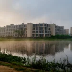 IIM Calcutta campus building beside the lake in Joka, Kolkata. AI-generated image grounded in a real photo by Swayam Soren, CC BY-SA 4.0, via Wikimedia Commons.