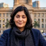 RBI Deputy Governor Poonam Gupta, with the RBI building in Mumbai behind her. Photo: Government of India via Wikimedia Commons, background composite.