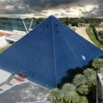 The glass pyramid of the Infosys campus in Bengaluru. Photo: Vinu Thomas / Wikimedia Commons (CC BY-SA 2.0), background composite.