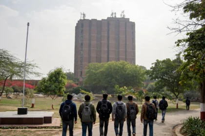JNU library tower on campus, students walking towards it. AI-generated image grounded in a real Wikimedia Commons photo of the JNU library building.
