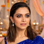 Deepika Padukone in a festive Dussehra-themed editorial image. Reference photo: Bollywood Hungama / Wikimedia Commons (CC BY 3.0); background AI-composited.