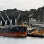 Cargo ship unloading raw sugar at a port refinery, representative image