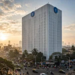 SBI headquarters building in Mumbai. Photo composite: Digamber / Wikimedia Commons (CC0) with AI-generated editorial background.