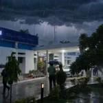 State Bank of India office under a stormy sky, building photo by Ganesh Dhamodkar / Wikimedia Commons (CC BY-SA 4.0), background composite
