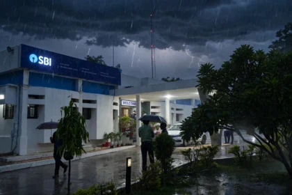 State Bank of India office under a stormy sky, building photo by Ganesh Dhamodkar / Wikimedia Commons (CC BY-SA 4.0), background composite
