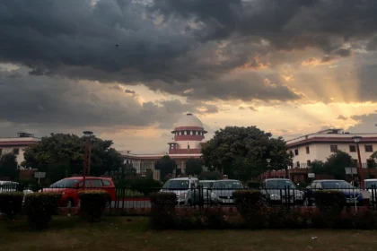 Supreme Court of India building at dusk. Photo: Pinakpani / Wikimedia Commons (CC BY-SA 4.0), editorial composite.