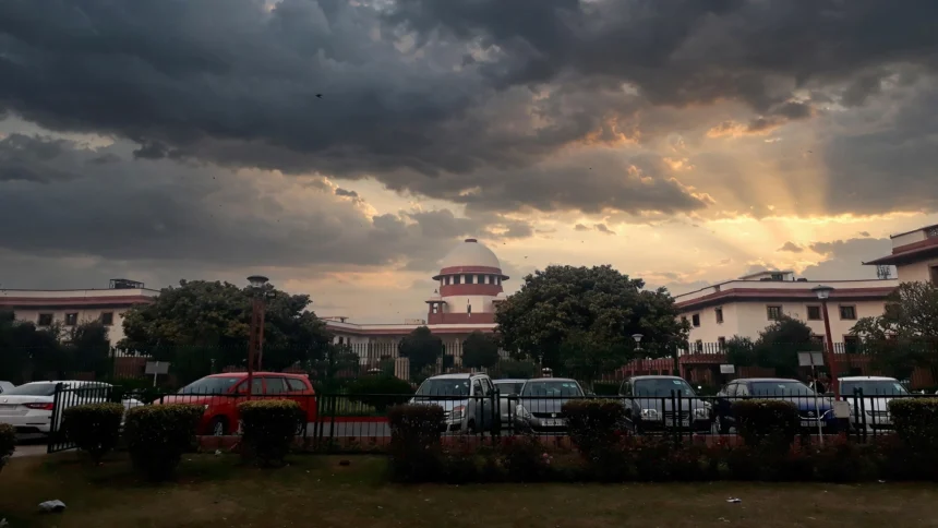 Supreme Court of India building at dusk. Photo: Pinakpani / Wikimedia Commons (CC BY-SA 4.0), editorial composite.