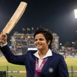 Shafali Verma raises her bat after a record 25-ball 55 for India (Photo: PMO India / Wikimedia Commons, background composite)