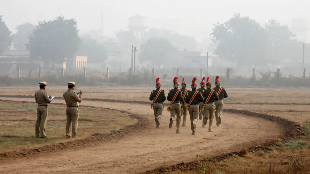 Police recruits running on a dirt track during a timed physical test, with officials watching. Image generated from a real reference photo (Antonio Milena / Wikimedia Commons, CC BY 3.0).