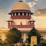 Supreme Court of India building at sunset. Photo: Subhashish Panigrahi / Wikimedia Commons (CC BY-SA 4.0), background composite.