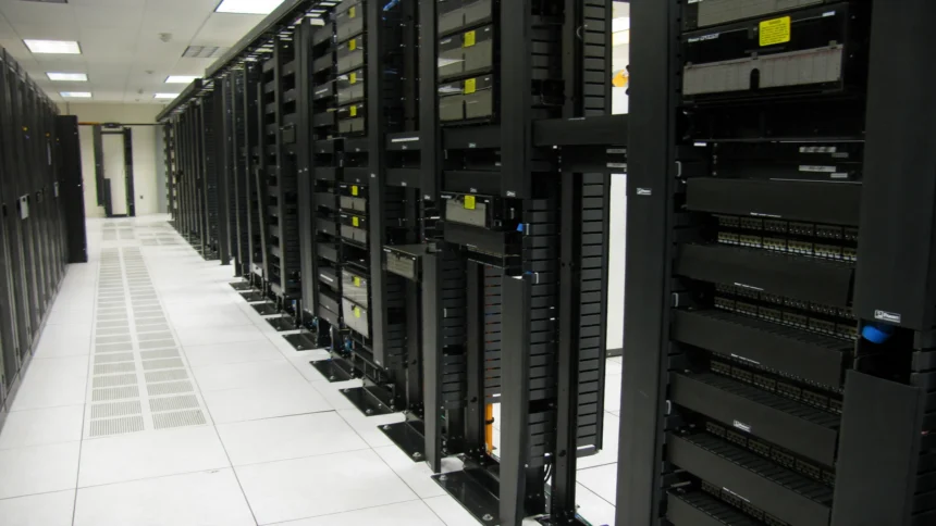 Rows of data centre server racks and fibre patch panels
