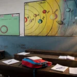 Indian school classroom in warm morning light, desks with notebooks and school bags, planets wall chart. Classroom reference photo: Anindya202414 / Wikimedia Commons (CC BY-SA 4.0), background composite