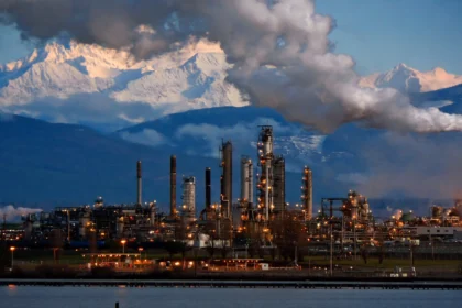 Oil refinery at dusk. AI image grounded in a real photo by Walter Siegmund, Wikimedia Commons, CC BY 2.5.