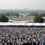 Large crowd at a Delhi maidan for a political rally, illustrative image grounded in a real Ramlila Maidan reference photo.
