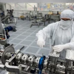 Engineers at work inside a semiconductor cleanroom (illustrative image based on a real cleanroom photograph)